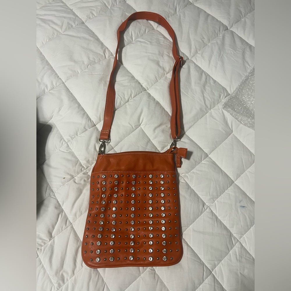 Cross body orange bag with gold accents.